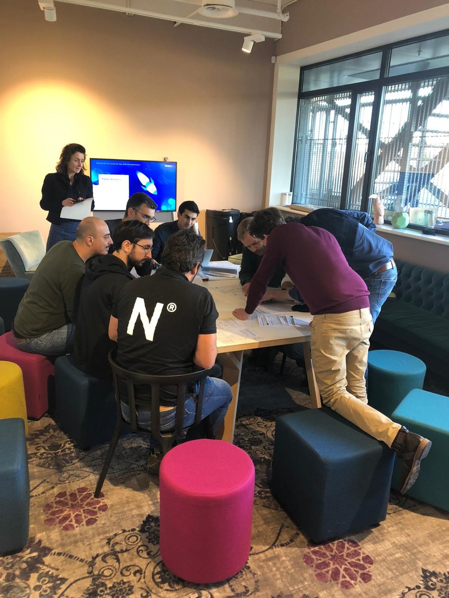 The picture is from one of our squad dynamics and it shows seven men and one woman around a wooden table, looking at a lot of papers and discussing amongst themselves.